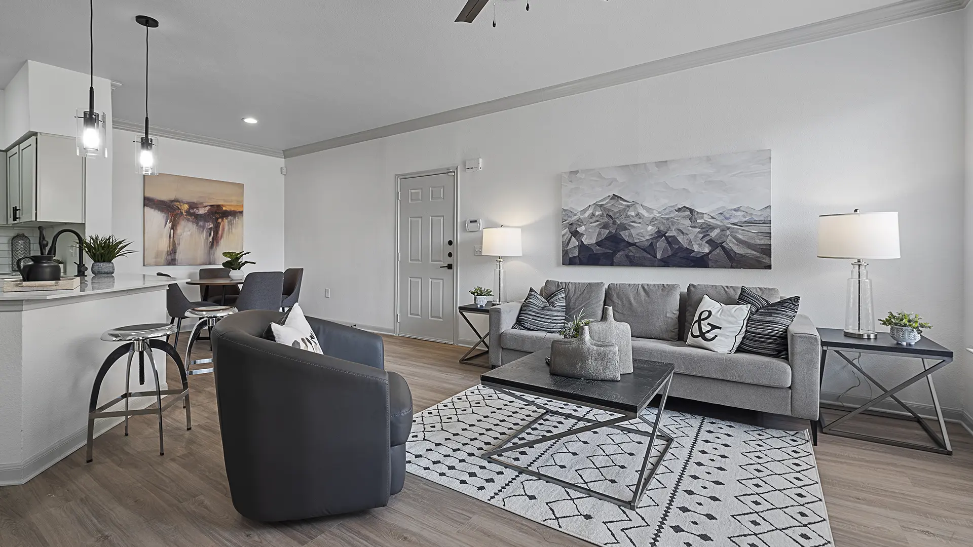 model living room with ceiling fan, modern furniture and crown molding