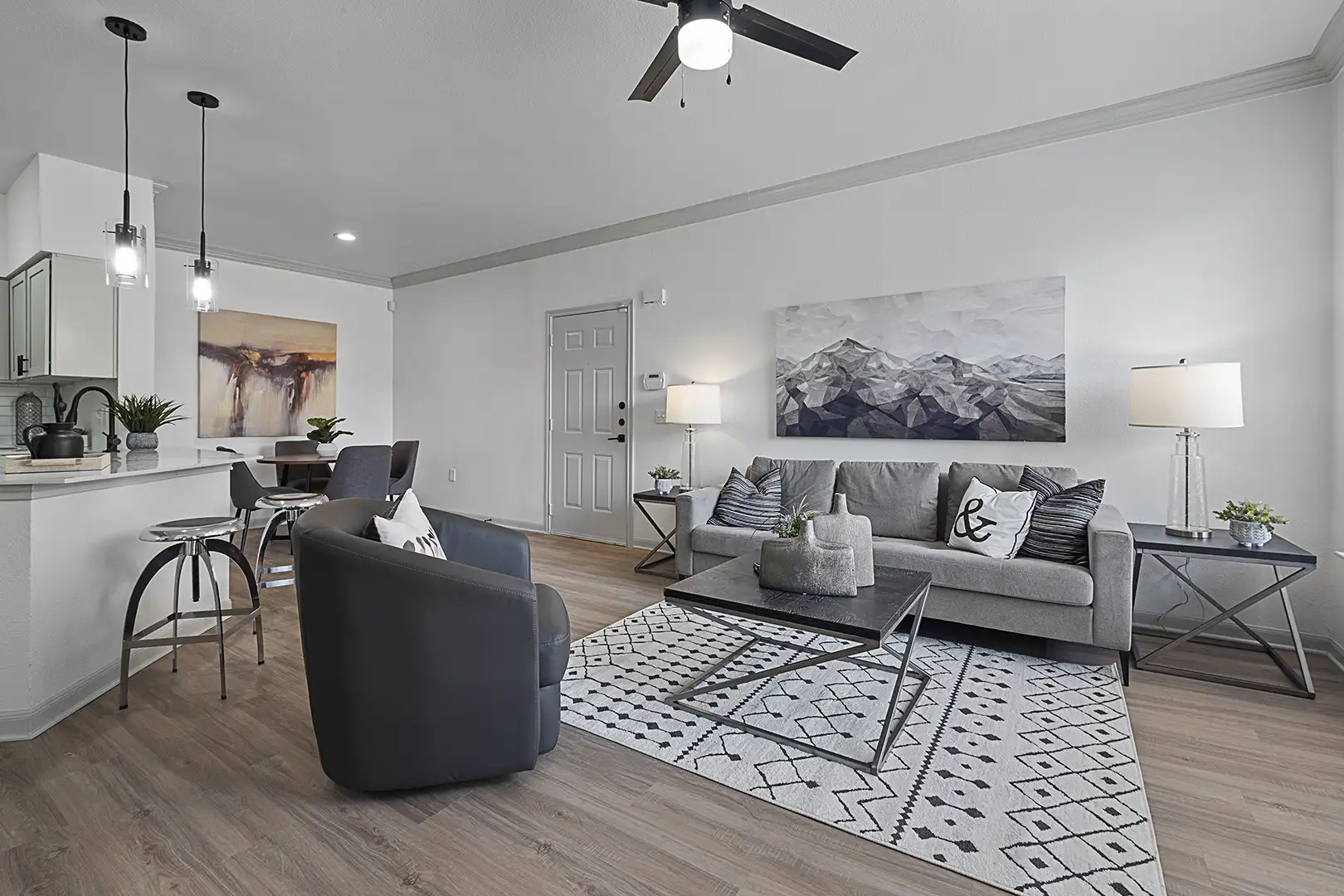 model living room with ceiling fan, modern furniture and crown molding