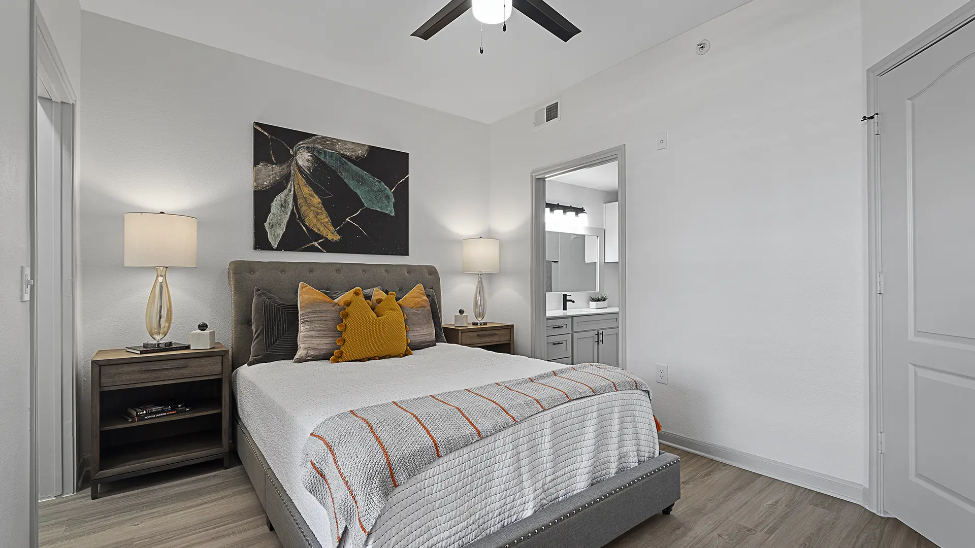 model bedroom with ceiling fan and plank flooring