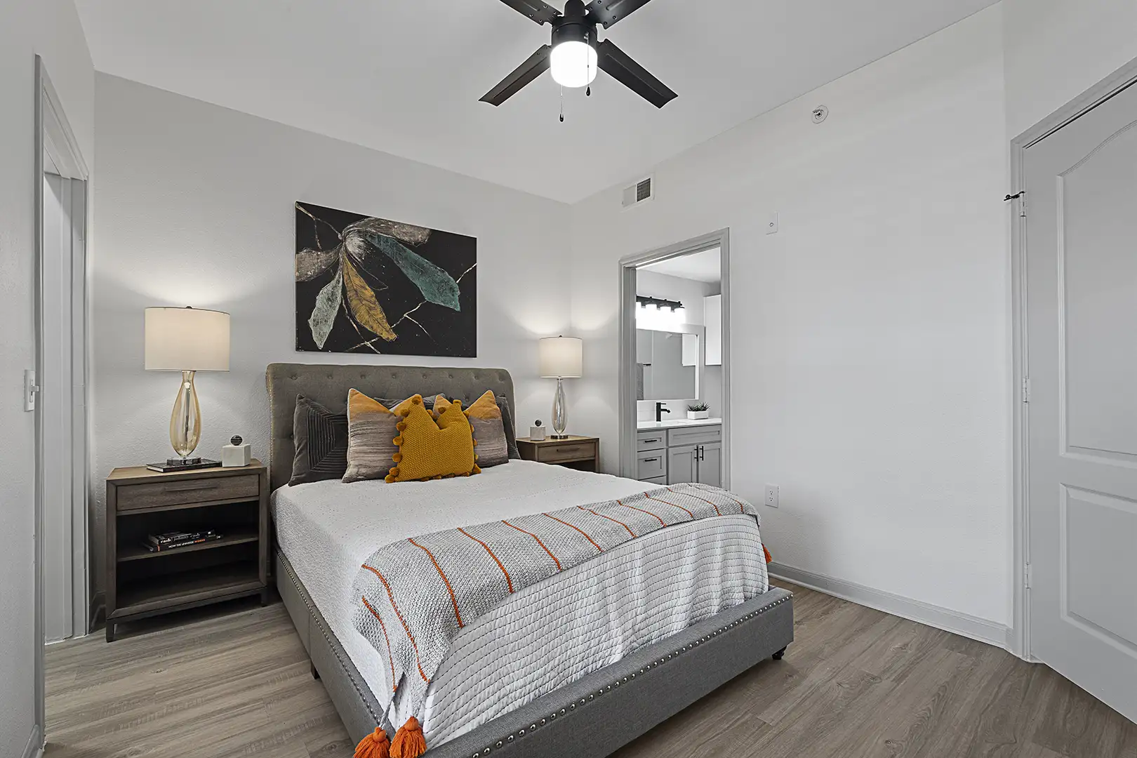 model bedroom with ceiling fan and plank flooring